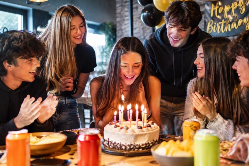 grupo de adolescentes celebrando un cumpleaños muy animados y sonriendo